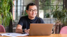 asian man browsing on a laptop